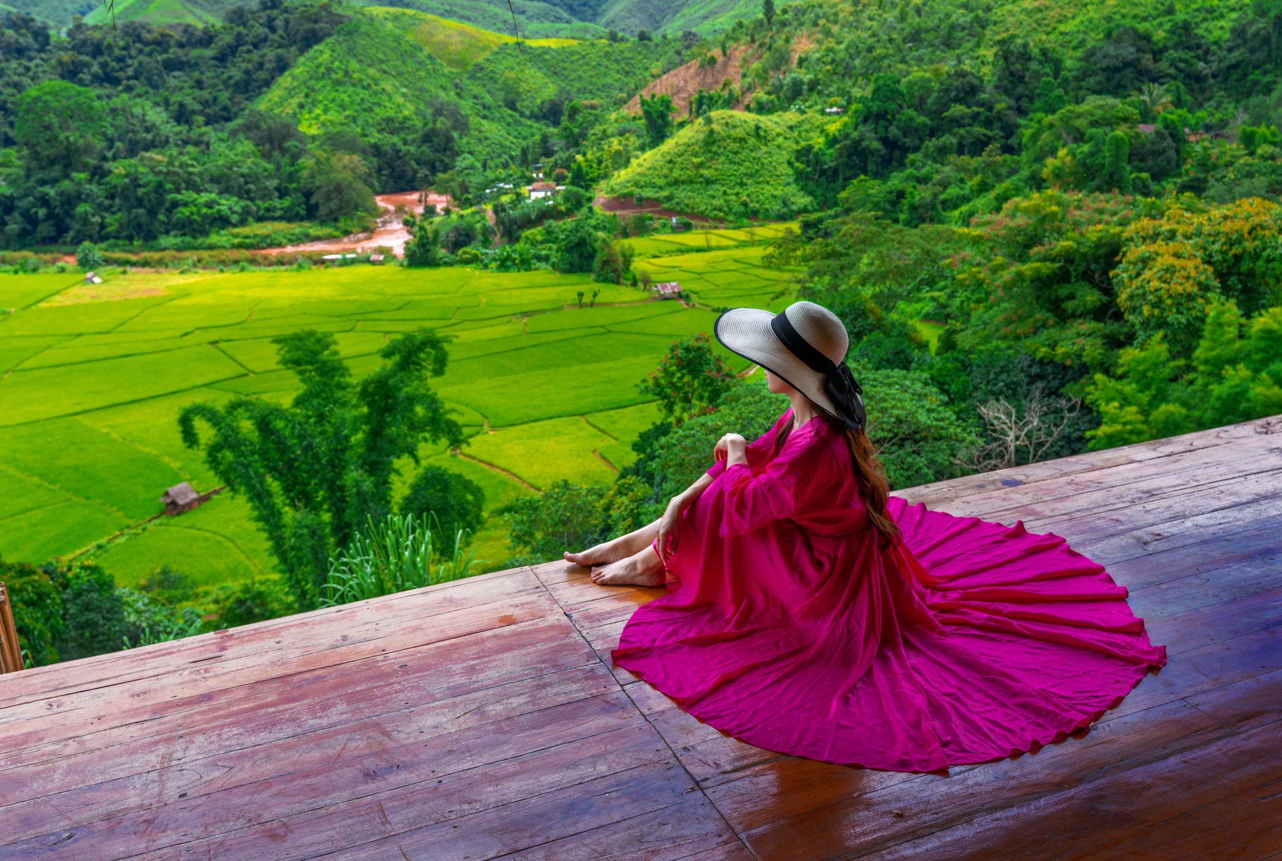 Woman In A Pink Dress Sits At The Resort Balcony Looking At The Rice Fields At Sapan Village