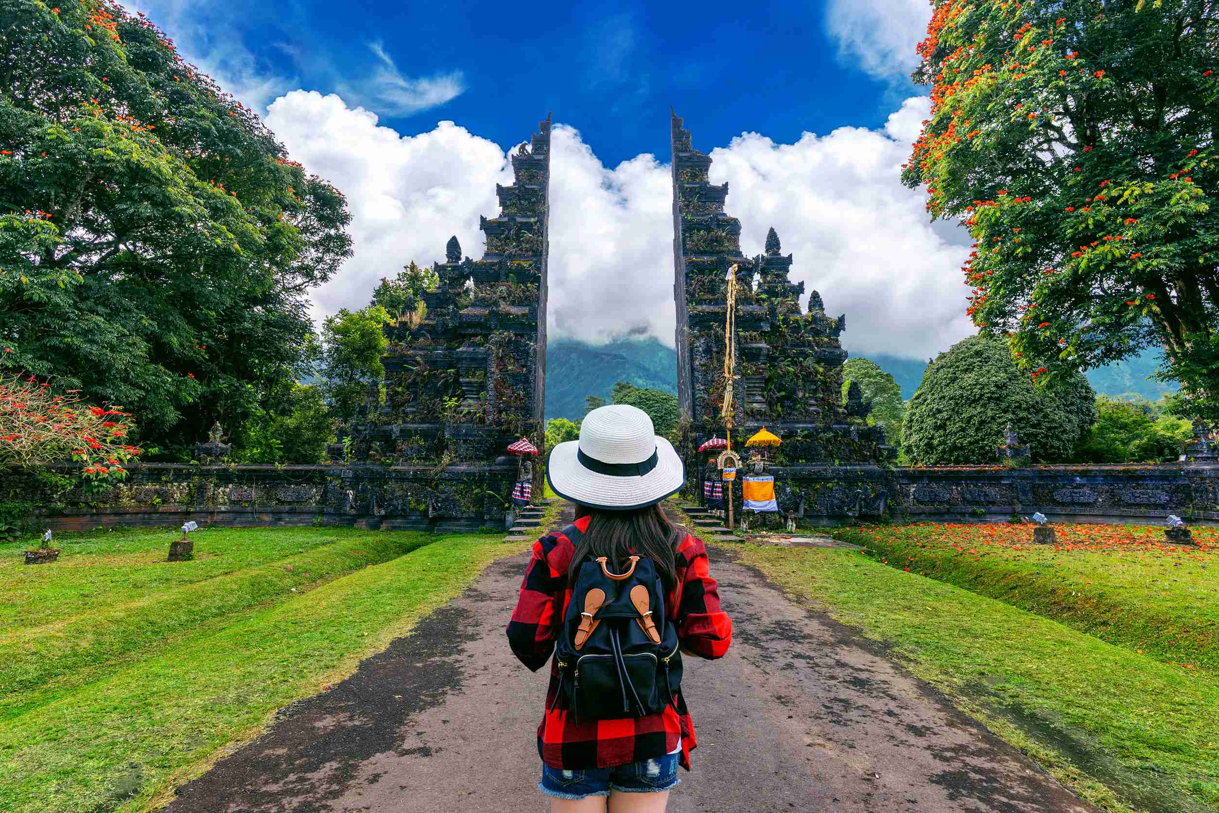 Woman Traveler With Backpack Walking At Big Entrance Gate In Bali Indonesia